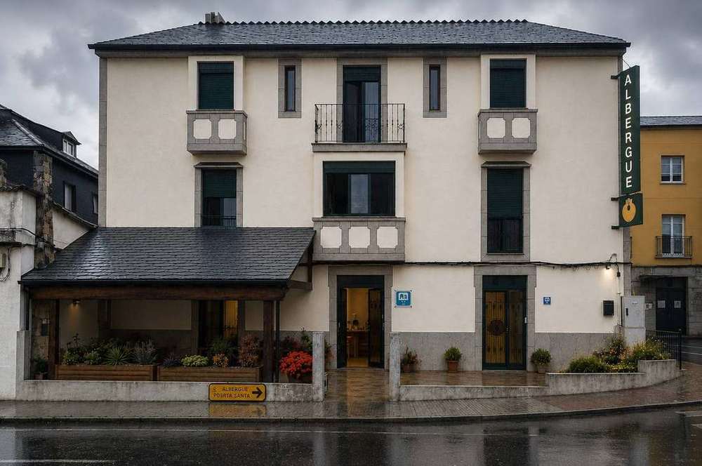 Fachada Albergue Porta Santa Lloviendo